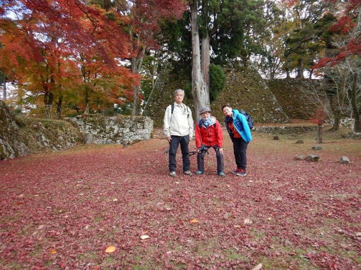 天守台を後ろに紅葉の赤いじゅうたんで記念撮影 イメージ